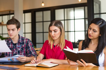 Três pessoas estudando.