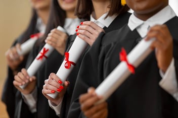 Mulheres segurando diplomas de sua formatura