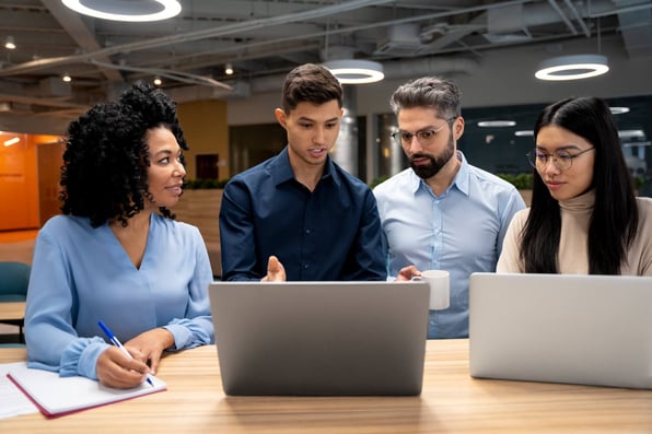 Grupo de pessoas debatendo assunto que está no computador