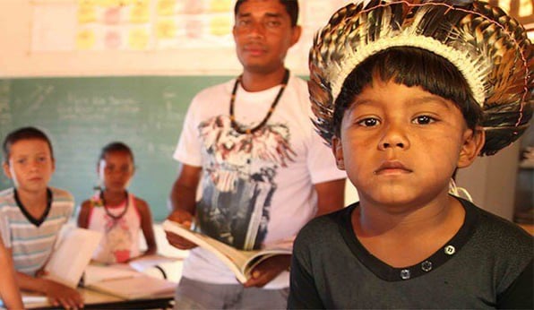 Estudantes e professores em sala de aula de escola indígena