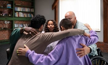 4 pessoas abraçadas.
