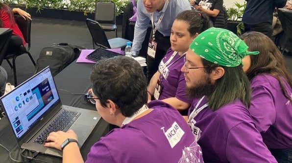 Jovens reunidos em frente a um notbook 