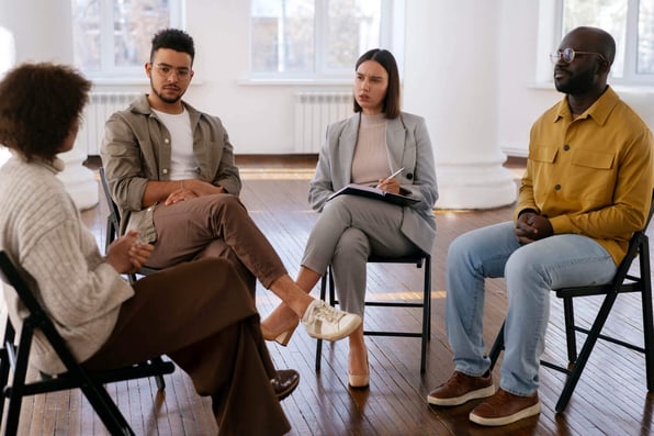 Pessoas sentadas em um circulo conversando