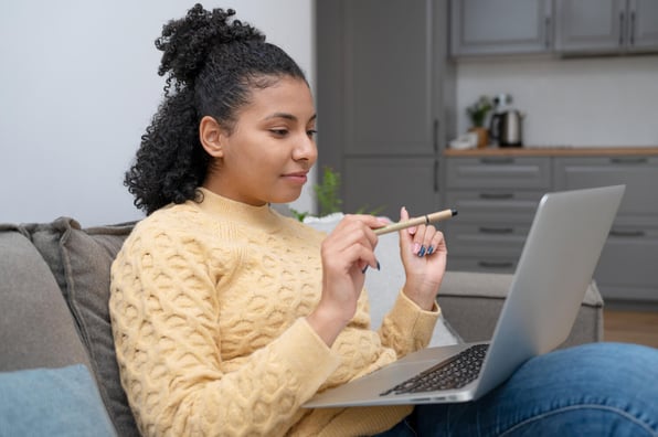 Mulher jovem, sentada em frente ao seu notebook