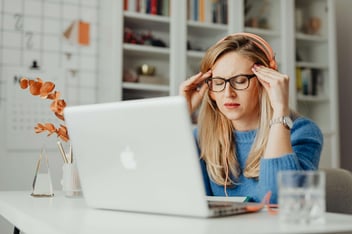 Mulher com os olhos fechados se concentrando em frente ao notebook.