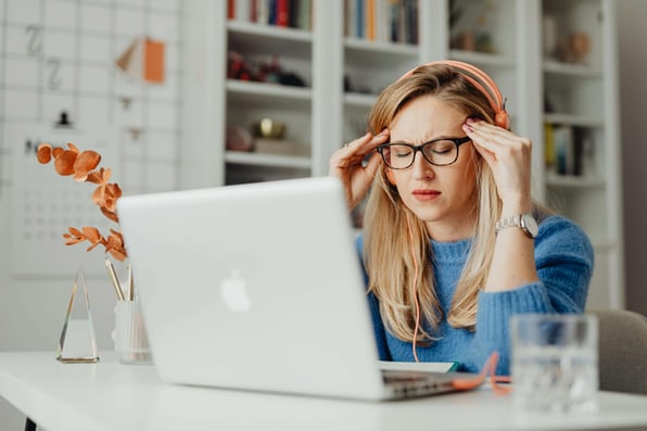 Mulher com os olhos fechados se concentrando em frente ao notebook.