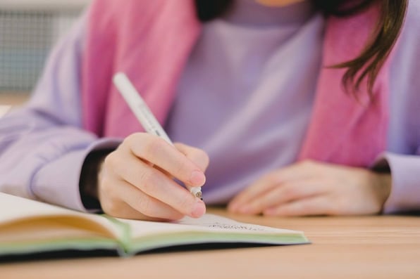 Menina escrevendo em seu caderno.