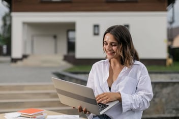 Mulher sentada com notebook no colo.