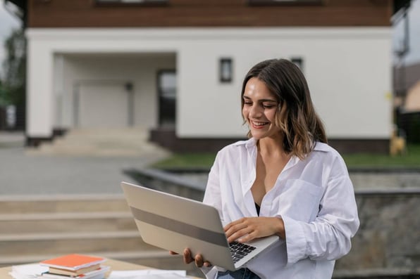 Mulher sentada com notebook no colo.