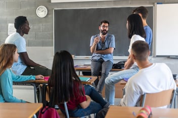 Professor conversando com grupo de alunos