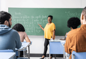 Professora dando aula em sala.