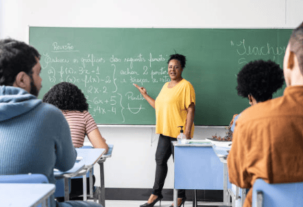 Professora dando aula em sala.