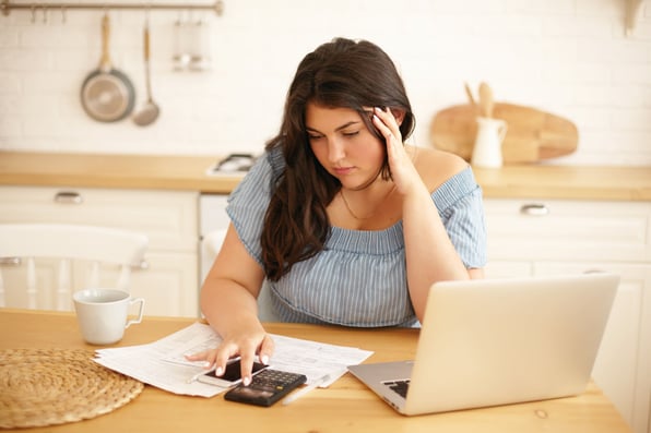 Menina preocupada, em frente a notebook.