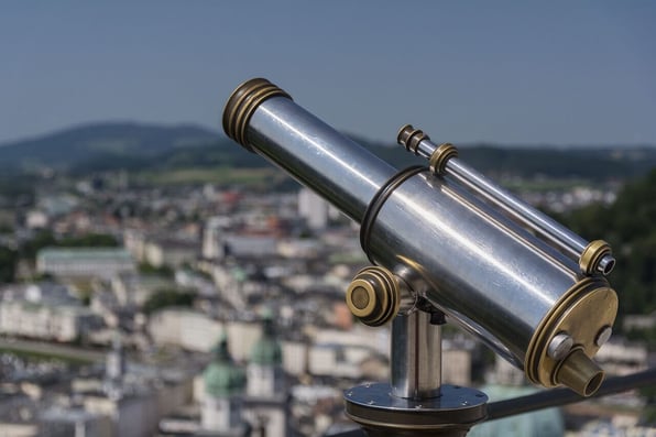 Telescópio e, ao fundo, uma cidade.