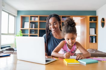 Mãe segurando a filha e mexendo no notebook