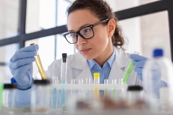 Mulher trabalhando em laboratórios com frascos.