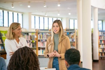 Mulher palestrando em biblioteca