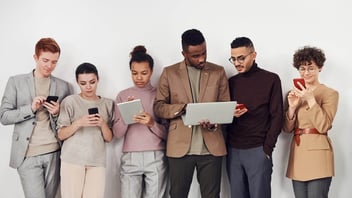 Grupo de jovens diversos utilizando aparelhos tecnológicos.