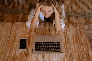 Menina em frente a notebook com as mãos sob a cabeça