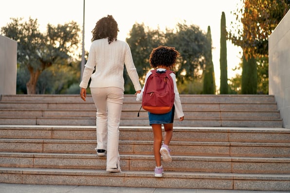 Mãe levando a filha para a escola 