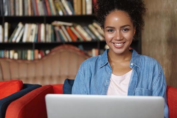 Mulher sorrindo em frente a notebook.